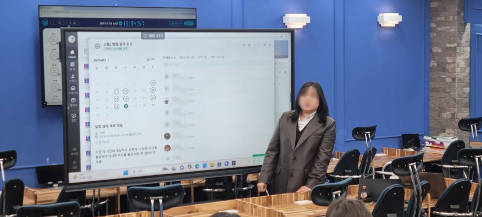 대형 전자칠판에 클래스인 과제 화면을 띄워 설명하는 선생님