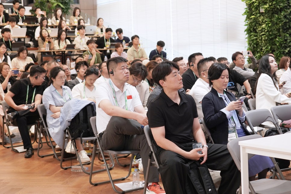 이어폰을 착용하고 발표에 귀 기울이는 포럼 참석자들
